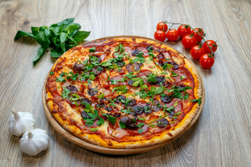 pizza with sausage, ham, salami, tomato sauce and parsley