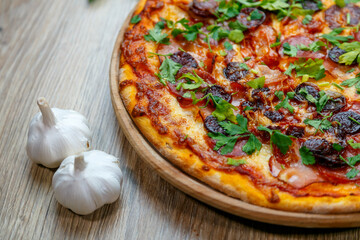 pizza with sausage, ham, salami, tomato sauce and parsley
