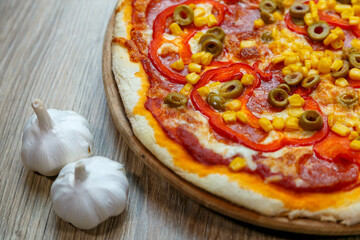 pizza with ham, mushroom, corn, green olives, red pepper and chesse