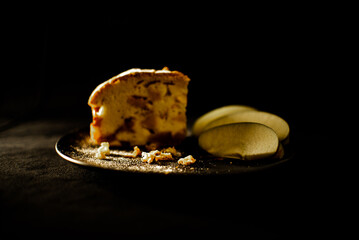 charlotte on a saucer with apples on a dark background