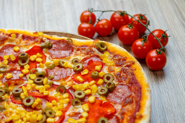 pizza with mozzarella, green olive, salami, corn and red pepper