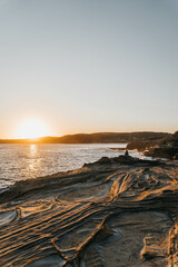 Obraz premium Stunning Sunset Over Rocky Foreground and Calm Ocean in Bouddi National Park, Central Coast, NSW, Australia