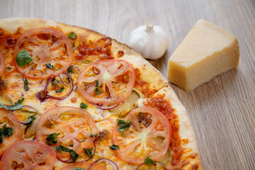 pizza with meat, mozzarella, tomatoes, spinach and tomato sauce