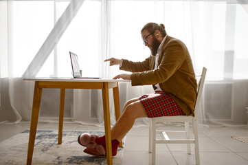 Angry freelance businessman pointing finger to laptop
