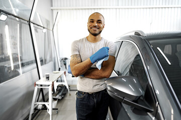 Portrait of African American man, car wash detailing service worker