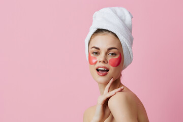 beautiful woman pink patches on the face with a towel on the head isolated background
