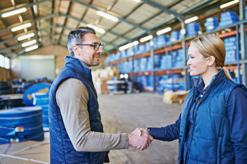 Awesome job on that last project. Shot of two people whaking hands while working in a warehouse.