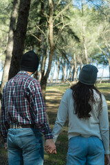 Fototapeta premium Back of a young couple during a trekking day in the wood