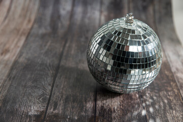 The disco ball is on a wooden brown table. The day of Valentine. Copy space