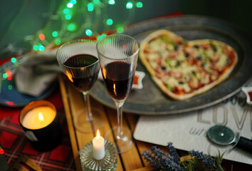 glasses of champagne. Romantic evening with heart shaped Pizza, lights. St Valentin's Day celebration. Love atmosphere. Holidays 