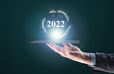 Businessman hand holding 2022 number,happy new year concept trends,industry and business