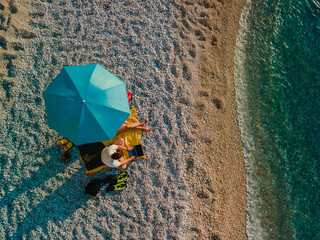 couple at the beach under sun umbrella sea vacation