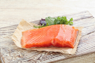 Raw salmon fillet over board
