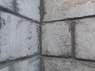 A fragment of the building wall (corner) made of large concrete blocks.