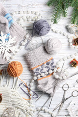 Flat lay of knitting and winter accessories on white background