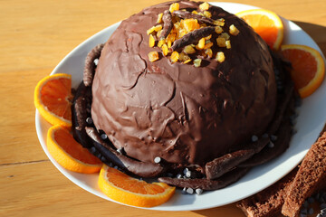 Italian traditional Zuccotto cake made with chocolate sponge cake ,chocolate and orange cream on plate on wooden table