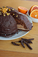 Cut Italian  Zuccotto cake made with chocolate sponge cake ,chocolate and orange cream on plate on wooden table