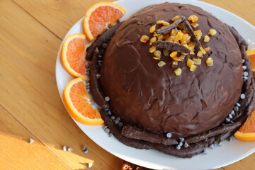 Italian traditional Zuccotto cake made with chocolate sponge cake ,chocolate and orange cream on plate on wooden table
