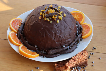 Italian traditional Zuccotto cake made with chocolate sponge cake ,chocolate and orange cream on plate on wooden table