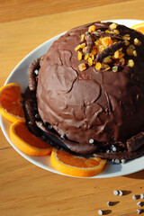 Italian traditional Zuccotto cake made with chocolate sponge cake ,chocolate and orange cream on plate on wooden table