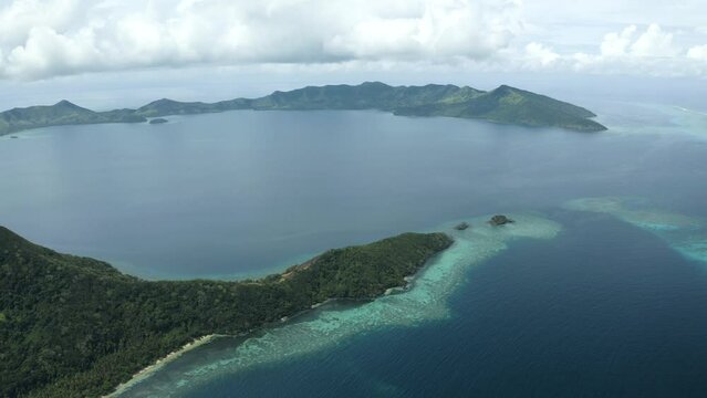 Aerial view of a stunning tropical island with a large lagoon in the South Pacific 