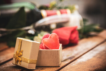 box of candies and heart gummies on wooden background. happy Valentines Day