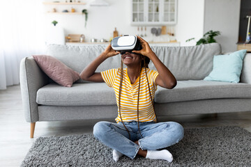 African-american woman using VR glasses, looking at copy space © Prostock-studio