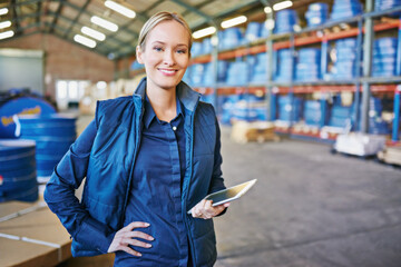 Tracking your order to its destination. Shot of a woman using a digital tablet in a large warehouse.