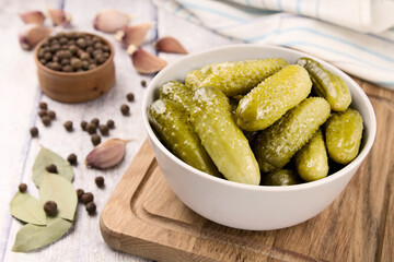 Pickled cucumbers in a bowl on a wooden rustic table