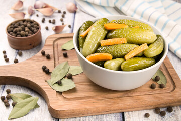 Pickled cucumbers in a bowl on a wooden rustic table