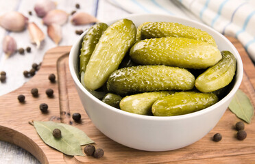Pickled cucumbers in a bowl on a wooden rustic table