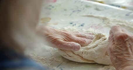 close-up, old women's grandmother's hands crumple dough with flour, prepare a pie for guests