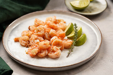 Grilled shrimps or tiger prawns served with lime, garlic and fresh herbs on scandi round plate on...