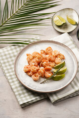 Grilled shrimps or tiger prawns served with lime, garlic and fresh herbs on scandi round plate on concrete surface. Pescatarian protein nutrition