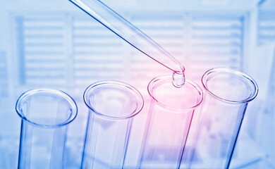Lab scene with pipette and test tube in blue with red focus