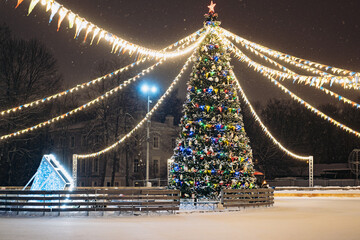 christmas tree at illuminated and decorated ice rink in city park