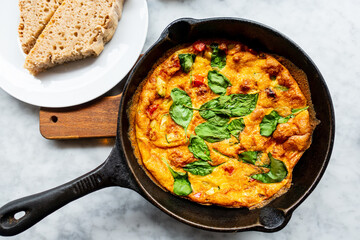 Delicious homemade omelet with vegetables cooked in oven and served in a traditional pan