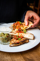 Delicious Mexican quesallidas made with chicken, tomato pieces and served with guacamole sauce.