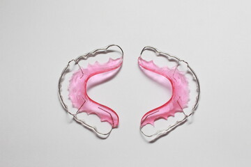 Retainer, colorful, pink, with wire bending, for wearing after orthodontics.