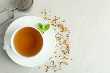 Concept of hot drink with buckwheat tea on light textured table