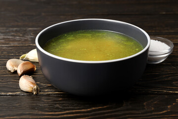 Concept of tasty food with chicken soup or broth on wooden background