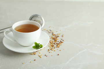 Concept of hot drink with buckwheat tea on light textured table
