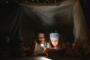 Little children reading bedtime story at home