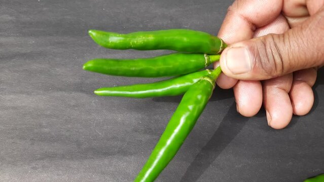 Green chili in black background. Its other name chilli pepper, chilli Nahuatl chilli. It is a spice that is added to many food items. Green chillies are rich in many nutrients such as Vitamin A, B6, C