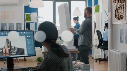 Architect analyzing building model and maquette in architectural office to design construction...