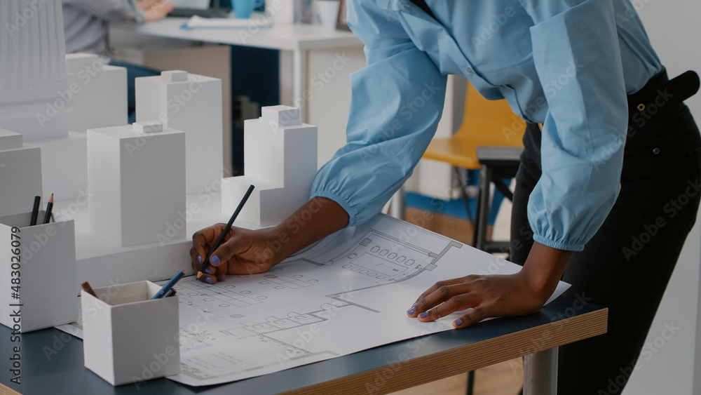 Poster close up of woman looking at blueprints plans to work on architecture project. architect working wit