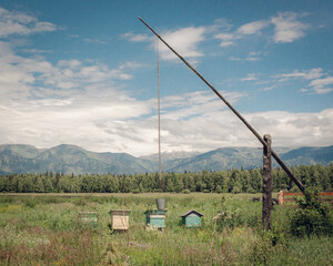 The landscape with shadoof and hives on the mountain background