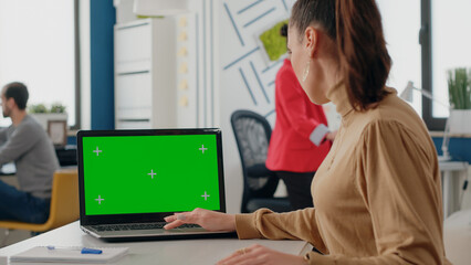 Close up of woman using green screen on laptop, working with isolated mock up background and blank...