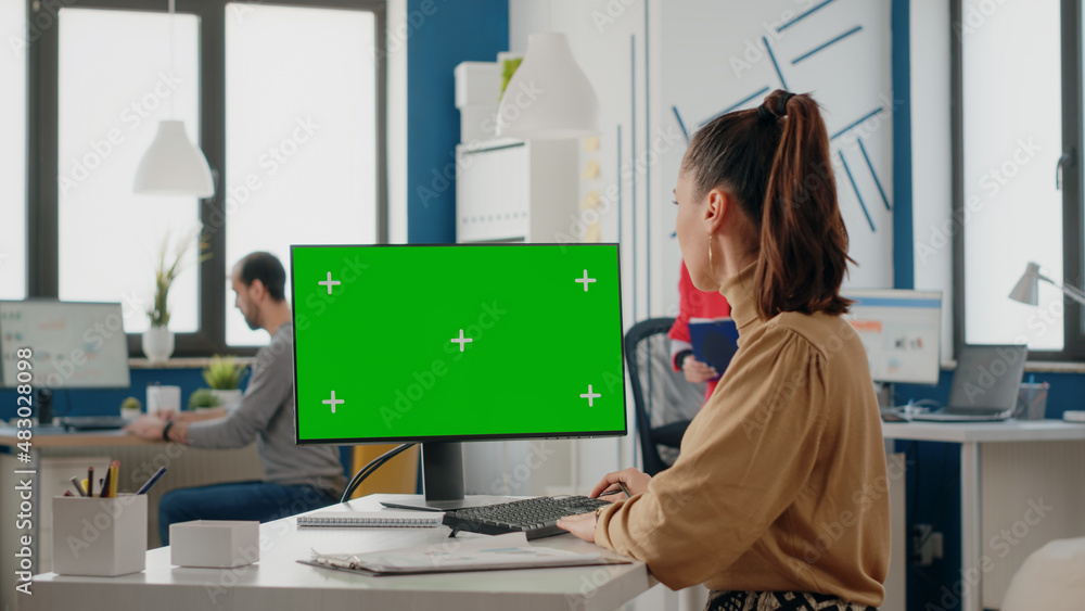 Poster colleagues working together with green screen on computer display. business women looking at compute
