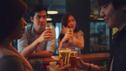 Group of Asian friend clinking a glass of beer and enjoy drinking beer at bar, alcohol, beer drinking, friend party, group of friend, casual meeting, bar and restaurant or friend and beer concept